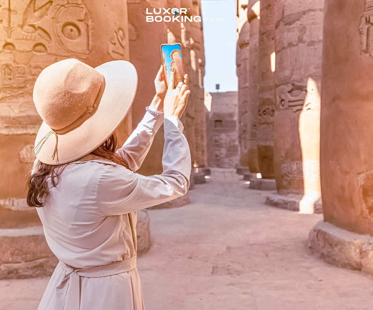 Traveler closely examining ancient reliefs inside a Luxor temple