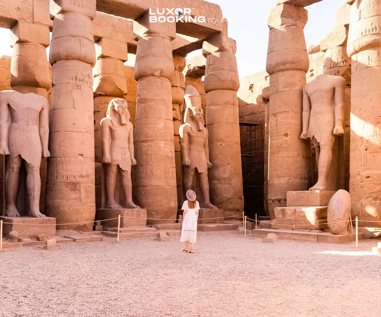 Traveler sitting quietly inside a Luxor temple courtyard