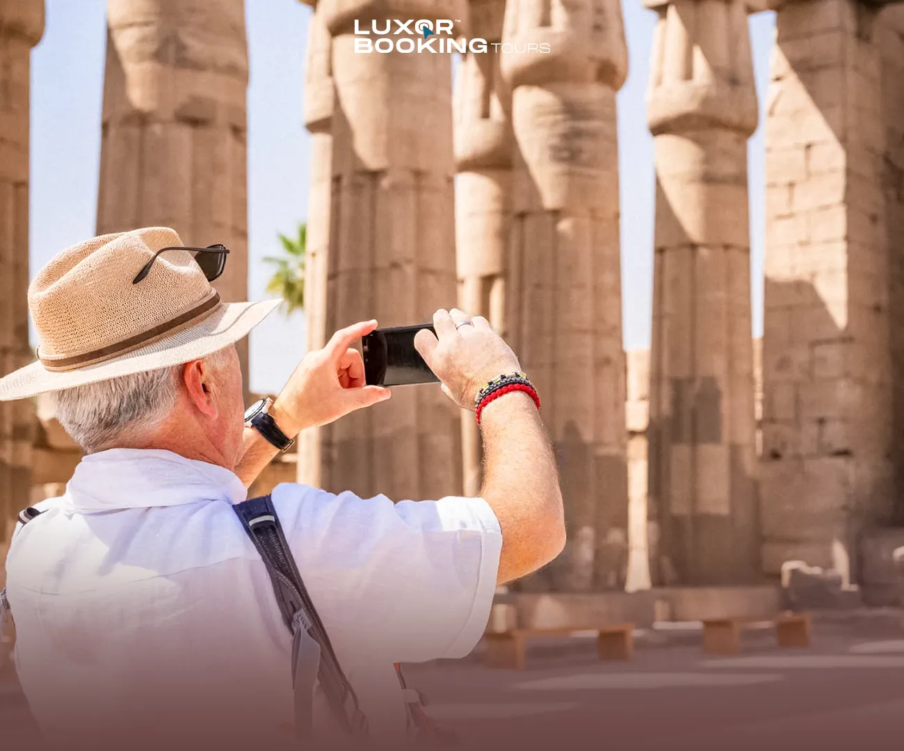 Traveler reviewing travel expenses while overlooking Luxor landmarks