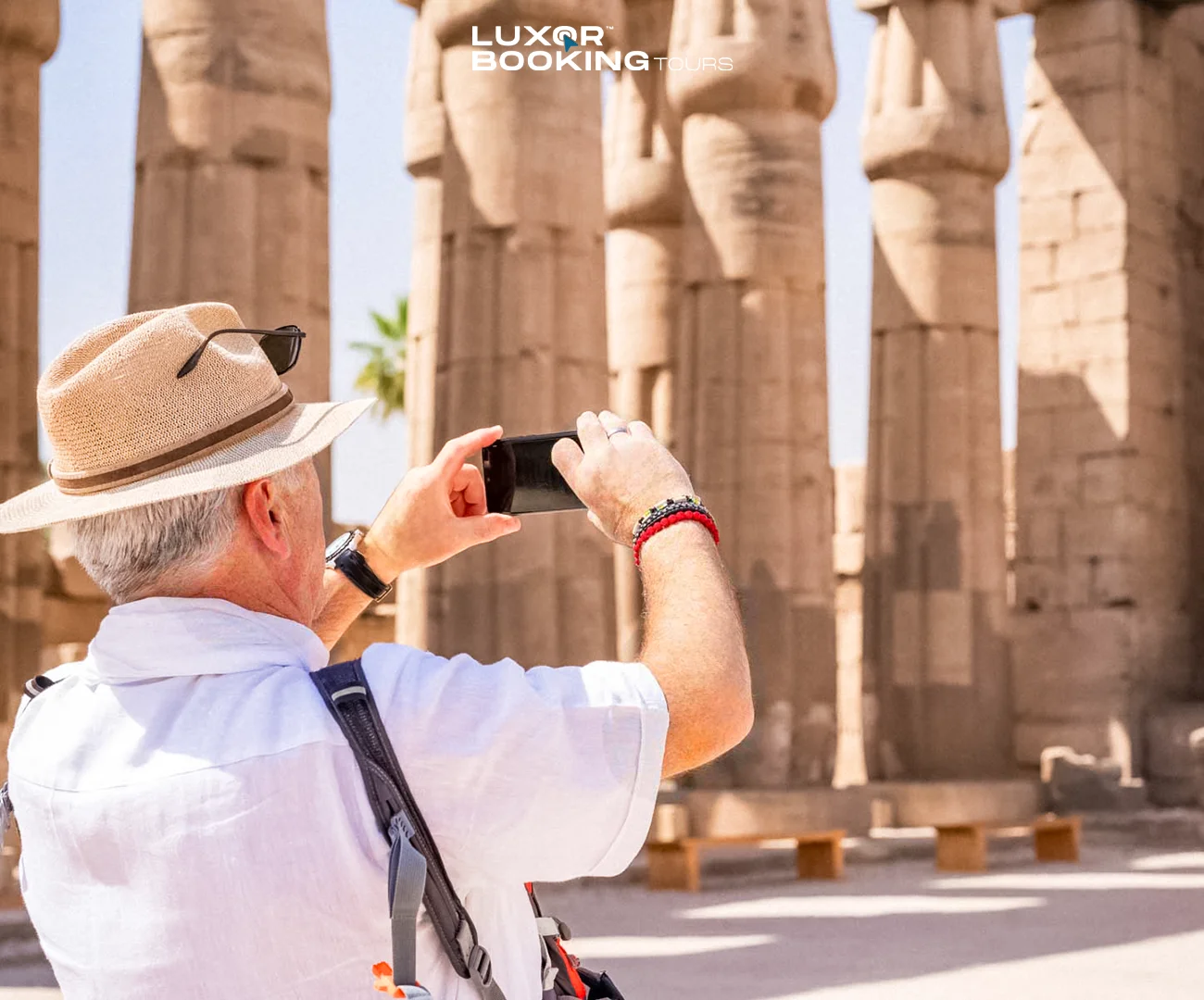 Traveler reviewing travel expenses while overlooking Luxor landmarks
