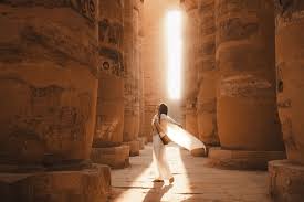 tourist resting in shade at luxor temple after walking in heat