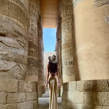 traveler standing inside large luxor temple space looking up