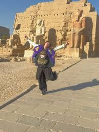traveler walking through large temple in luxor under sunlight
