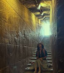 traveler standing quietly inside ancient egyptian temple in reflective mood